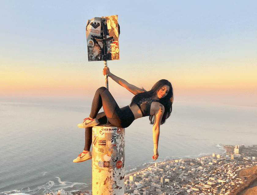 Nicole suspended on top of a modern pillar
