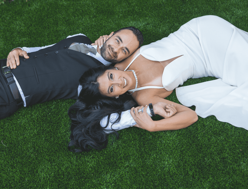 Nicole and Andrea lying on a grass feild with marriage dresses.