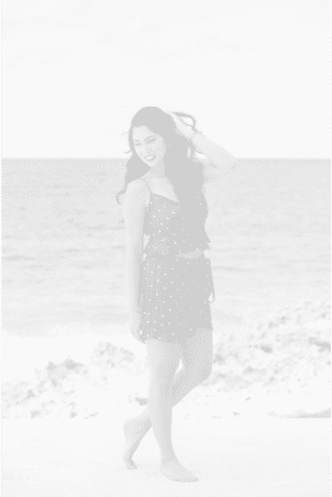 Nicole walking on a beach near the sea.